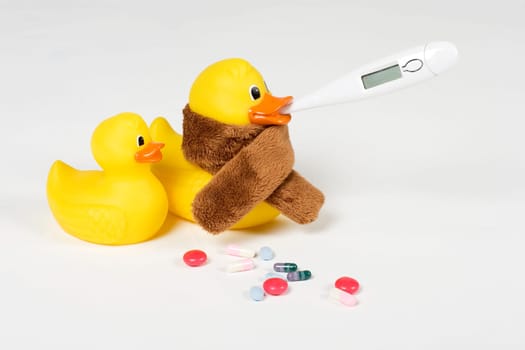 sick rubber ducks with clinical thermometer and tablets