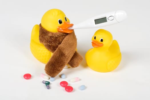 sick rubber ducks with clinical thermometer and tablets