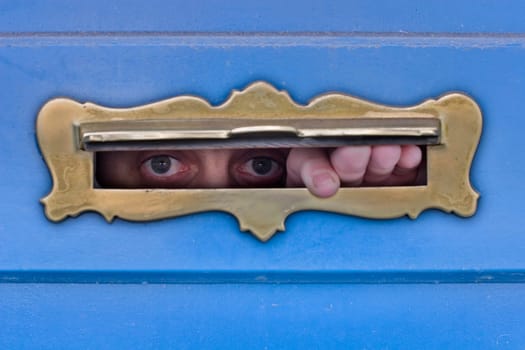 Man looking through letter slot