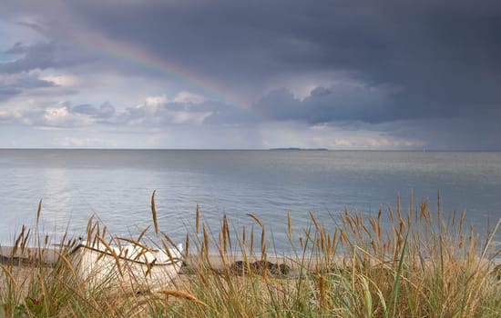 Boat on the beach with sea and thunderstorm front in the background
