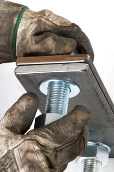Hands screw two steel plates together