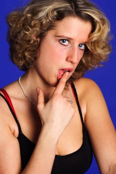 Woman sitting on a bar stool,finger lying erotically on her lips