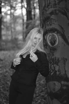 A woman stands smiling at the tree