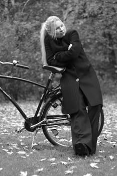 Woman with bicycle looking thoughtfully into the distance