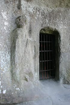 Guardian figure next to the grotto entrance in the Externsteine