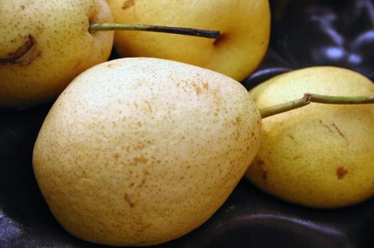 Nashis,like our native apples and pears,belong to the rose family. They are also known as Japanese or Asian pears. Nashis have a thin,yellow to light green edible skin and light,juicy flesh with many stones