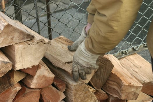 Construction of a wooden fin - close-up of hands in work gloves with logs