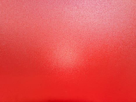 background of red shagreen powder paint coating on flat sheet steel surface.