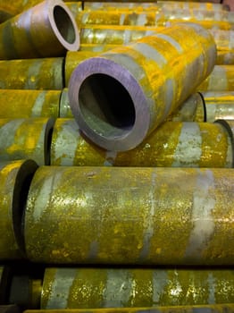 rusted thick steel pipe chunks after sawing waiting for machining operations.