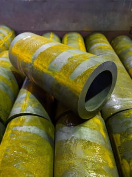 rusted thick steel pipe chunks after sawing waiting for machining operations.