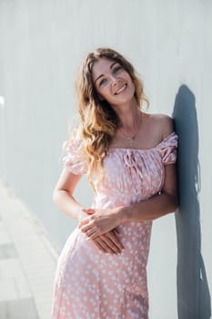 woman in a dress against the wall on the street for a walk