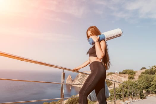 Fitness woman sea. Outdoor workout on yoga mat in park near to ocean beach. Female fitness pilates yoga routine concept. Healthy lifestyle. Happy fit woman exercising with rubber band in park.