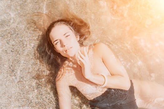 Woman travel sea. Young Happy woman in a long red dress posing on a beach near the sea on background of volcanic rocks, like in Iceland, sharing travel adventure journey