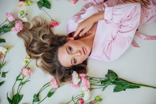 blonde woman in pink dress with flowers lying in the room