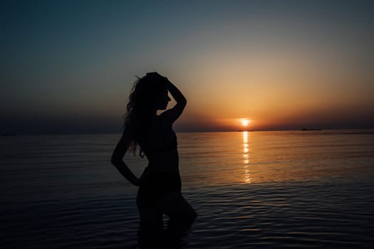 silhouette of a woman at sunset at sea rest beach walk