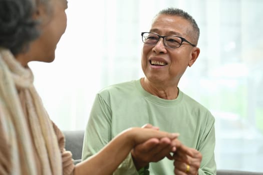 Caring senior man holding hands middle aged wife, spending the day together at home.