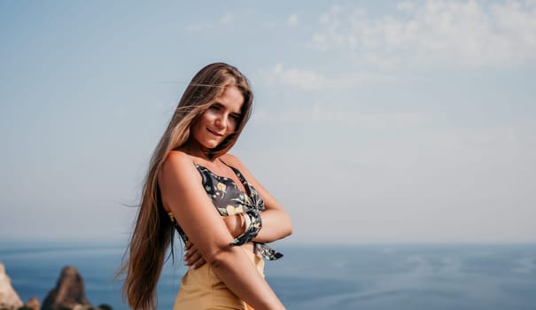 Woman travel sea. Happy tourist taking picture outdoors for memories. Woman traveler looks at the edge of the cliff on the sea bay of mountains, sharing travel adventure journey.