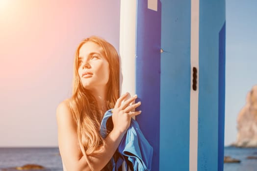 Close up shot of happy young caucasian woman looking at camera and smiling. Cute woman portrait in bikini posing on a volcanic rock high above the sea