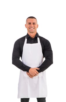 A man in an apron posing for a picture. Photo of a man wearing an apron, a waiter or cook, isolated on white background, smiling to the camera