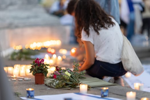 Lisbon, Portugal October 10, 2023. A woman, flowers and candles at the memorial to the fallen Israelis in October 2023. Mid. shot