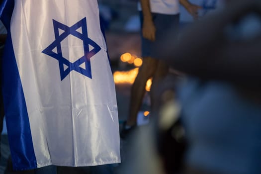 Lisbon, Portugal October 10, 2023. The flag of Israel in close-up on the background of a rally in support of Israel at dusk. Mid. shot