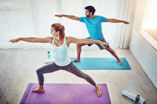 Couple, yoga and stretching in home or studio fitness, exercise and holistic training, teamwork or training. People or personal trainer in warrior pose for balance, mindfulness and workout together.