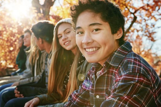 Teenager, group and portrait in park, boy and together on holiday, nature and relax by trees. Youth culture, happy friends and gen z school kids in sunshine, woods or garden for vacation in Canada.
