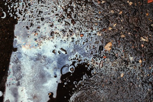 iridescent spot of gasoline on pavement
