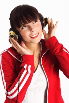A woman sits smiling with headphones and listening to the music