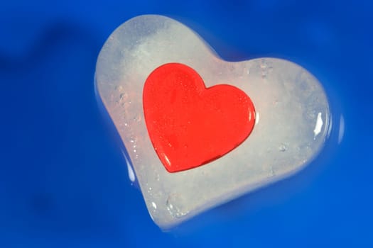 Red plastic heart frozen in ice heart