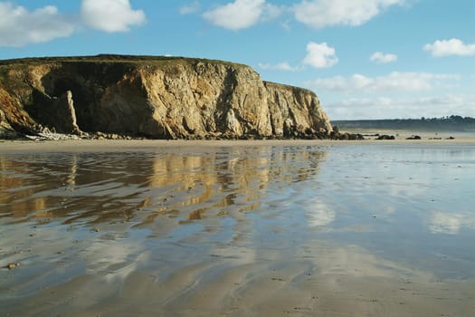 Reflecting water on a sandy beach in Brittany,France.