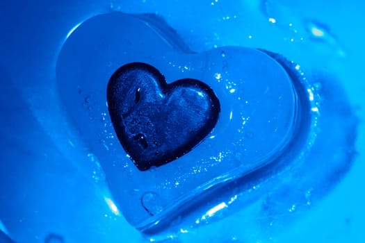 Heart frozen in the ice heart,illuminated with blue light.