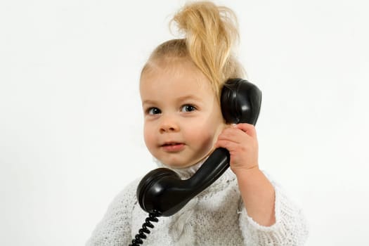 Small child talking on the phone with an old phone
