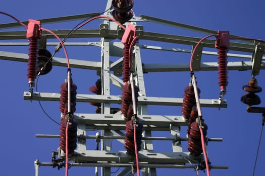 Power pylon with transformer in front of blue sky