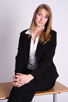 Business woman sitting smiling on desk