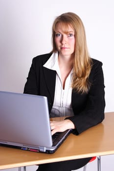 a secretary sits at the computer with a smile