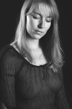 Photo shows a woman looking down longingly.