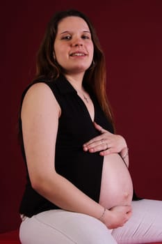 Photo shows a seated pregnant woman
