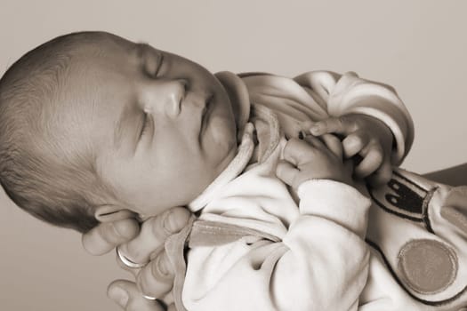 Photo shows a sleeping baby on the mother's hand