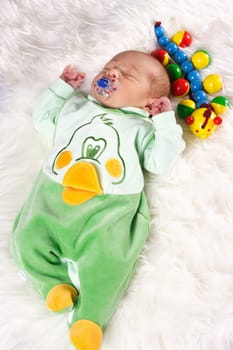Photos shows a sleeping baby with wooden toys