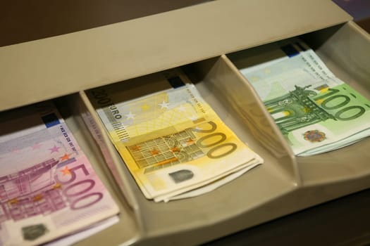 Euro banknotes in a cash register with note compartments