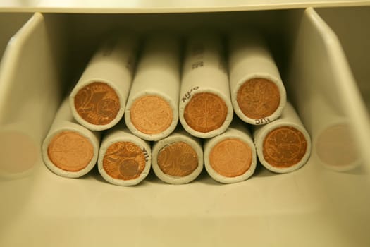 Rolled 2 cent coins in a coin box