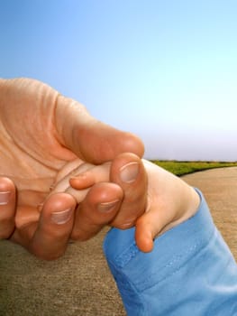 A father takes his child by the hand.