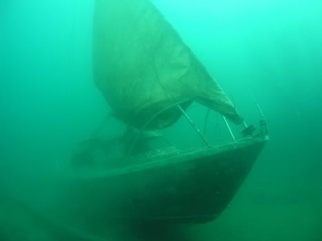 For some time now,this small sailboat with hoisted sail has been moored in the chalk lake Hemmoor.