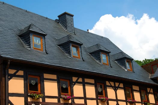 Half-timbered house with slate-covered gable roof and hipped dormers Germany