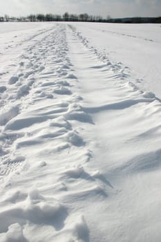 Snowy dirt road with footprints