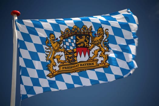 Flag of the Free State of Bavaria in front of a cloudless sky