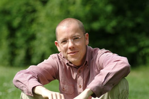 Young man sitting in a meadow