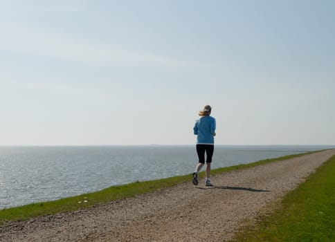 Woman jogging by the sea