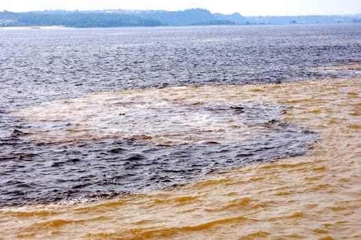 Meeting of the Waters: At the confluence of the Amazon brown water and Rio Negro black water Manaus,Brazil